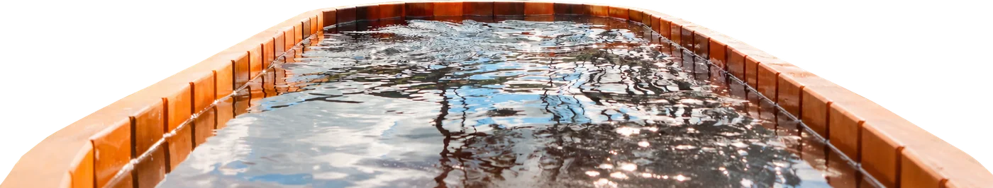 The cedar hot pool, full to the brim, the sky caught in the water