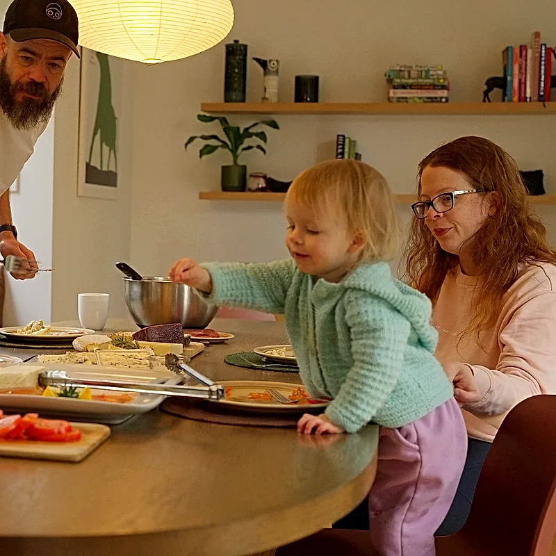 A family sharing lunch around the eco-lodge dining table