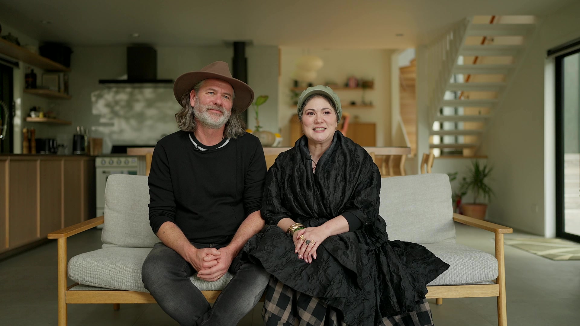 Owners Damon and Dianna sitting together on the sofa in the eco-lodge